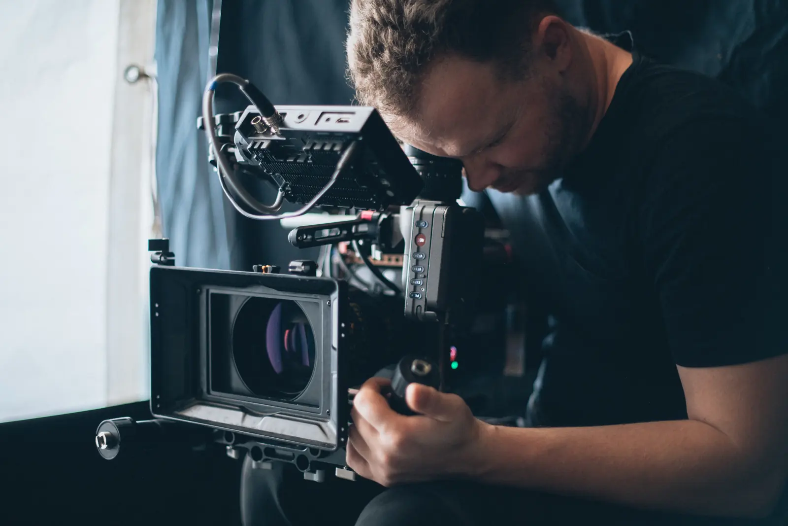 A cinematographer with a cinema camera on set