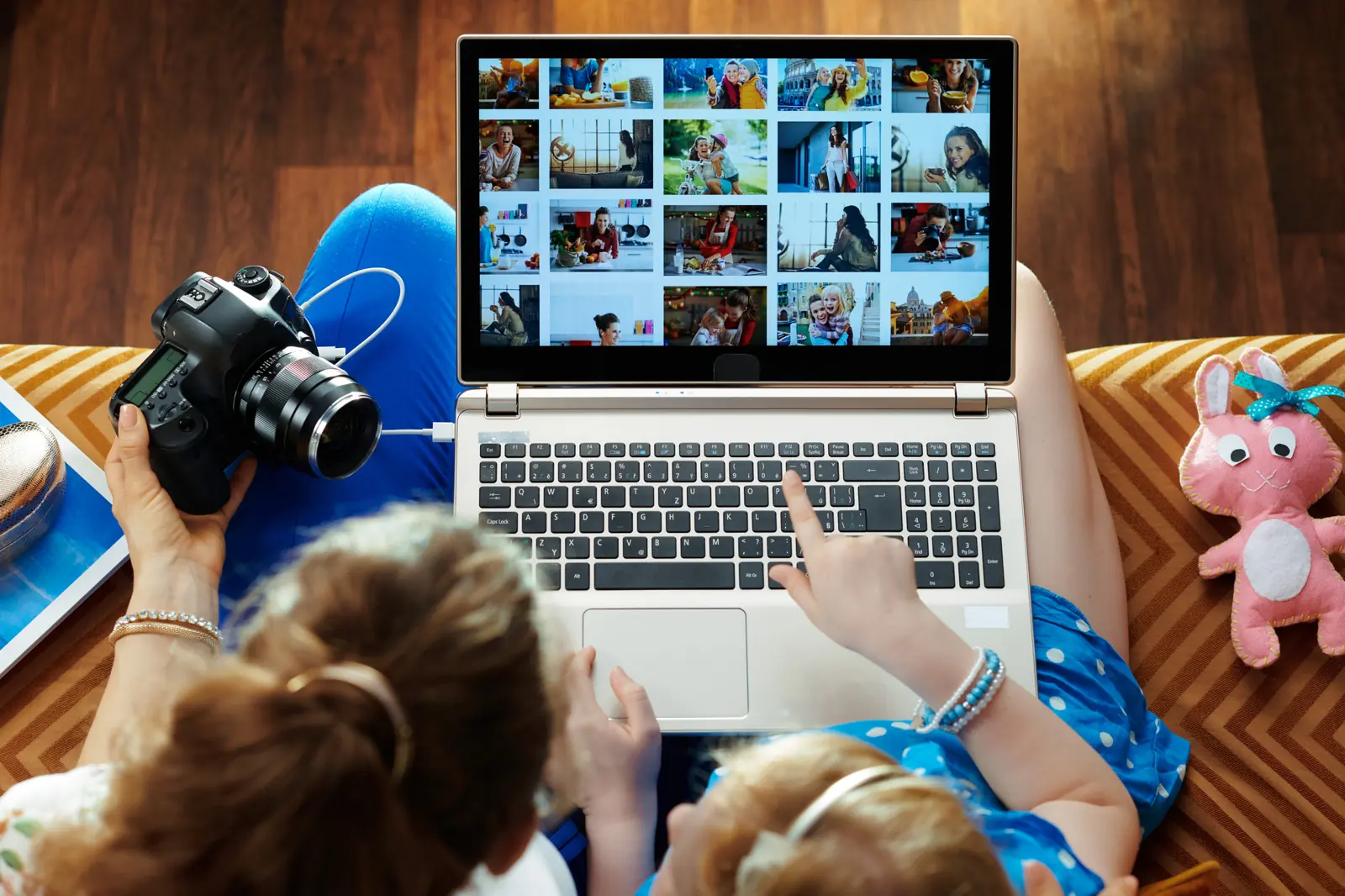 A mother and child looking through a photo gallery on a laptop