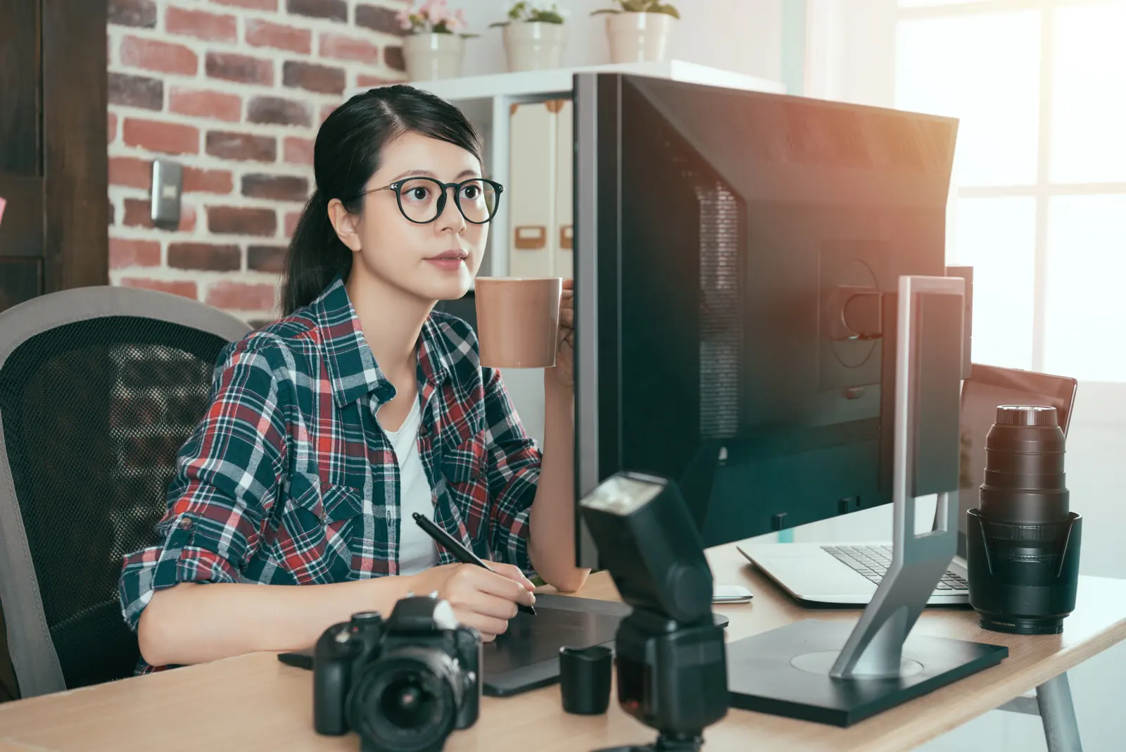 A photo editor at her desk with a camera beside her