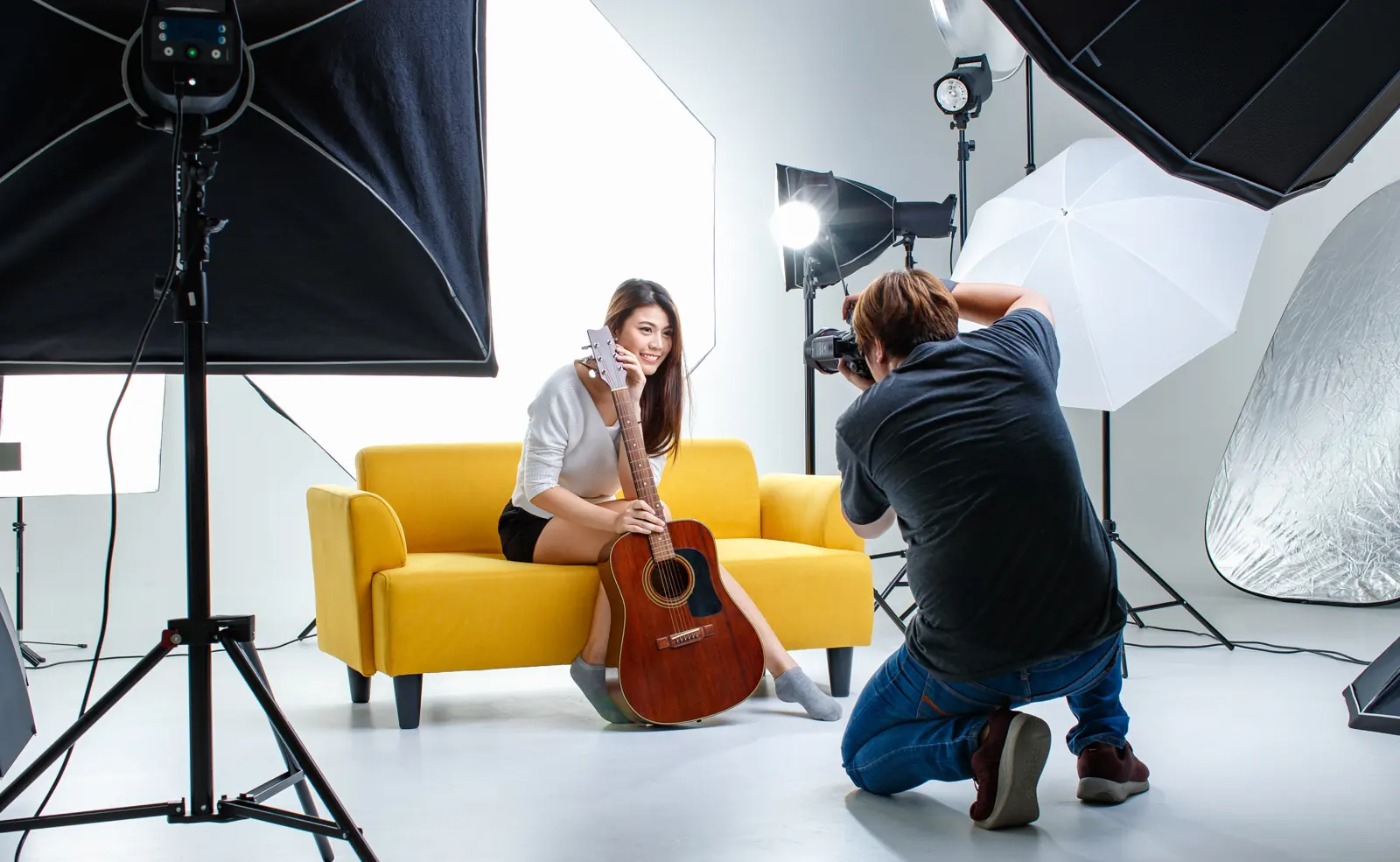 A photographer shooting a portrait in a lit studio