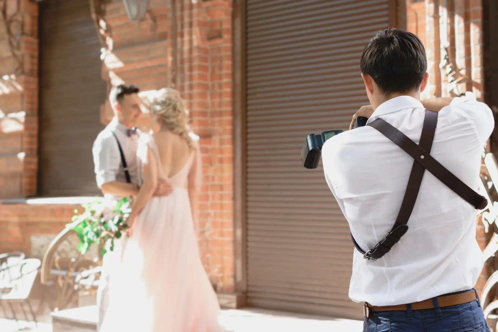 A wedding photographer photographing a bride and groom